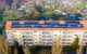 Communautés énergétiques urbaines : la ville productrice face aux inégalités d’accès Panneaux solaires sur toiture d'immeuble collectif en zone urbaine